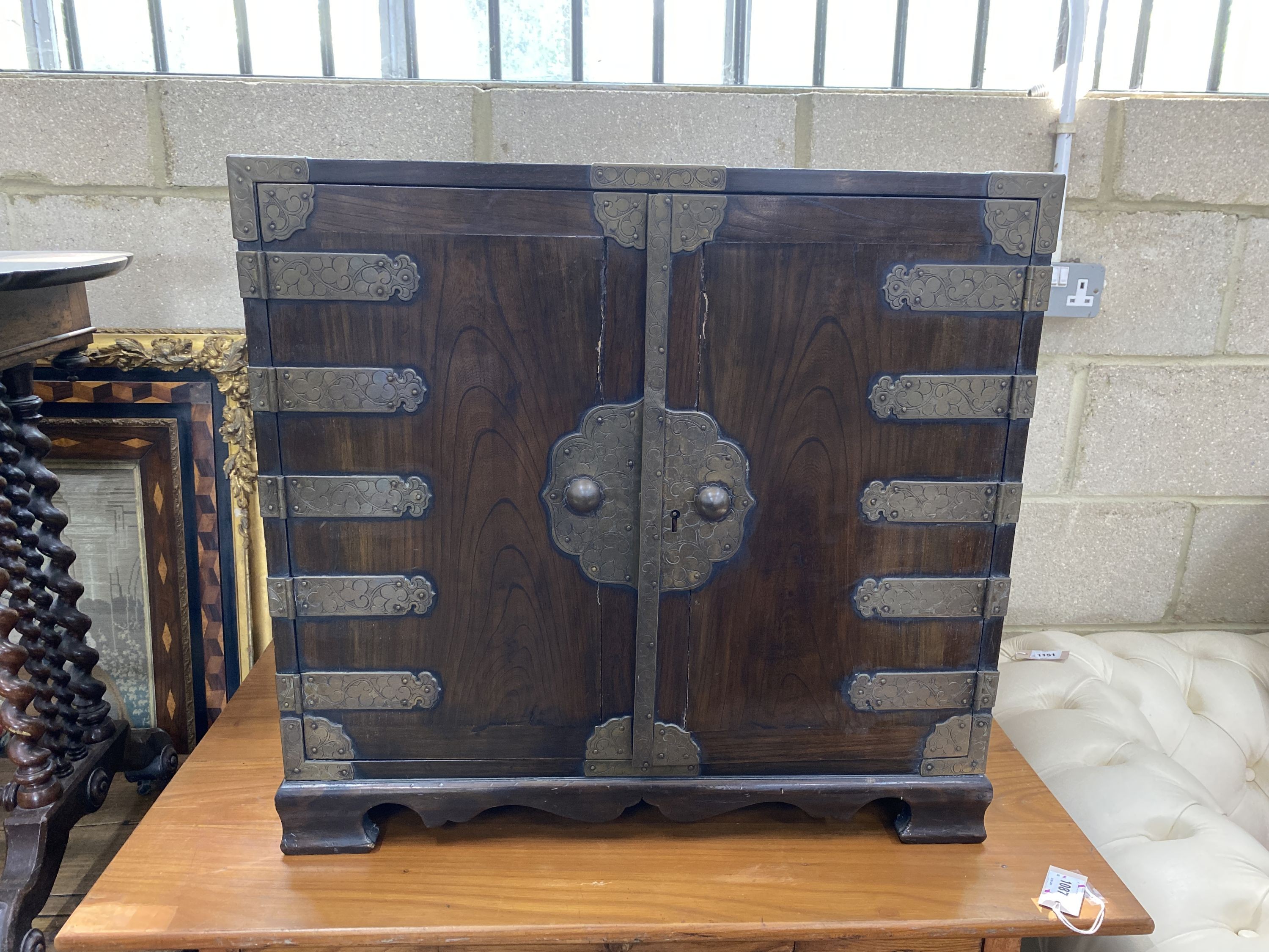 A Korean brass mounted pine table cabinet fitted with an arrangement of drawers, width 70cm, depth 40cm, height 66cm